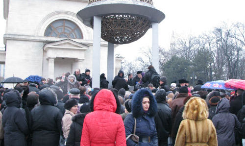  Несмотря на дождь, люди выстроились в длинные очереди, чтобы наполнить принесенные с собой сосуды освященной водой. 