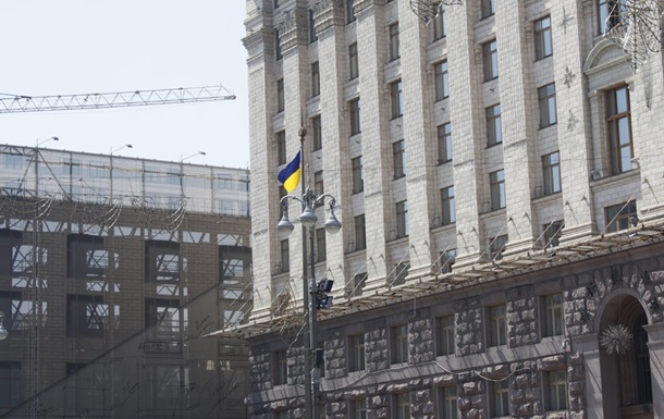 Входную дверь в здание перекрыли деревянными палками.