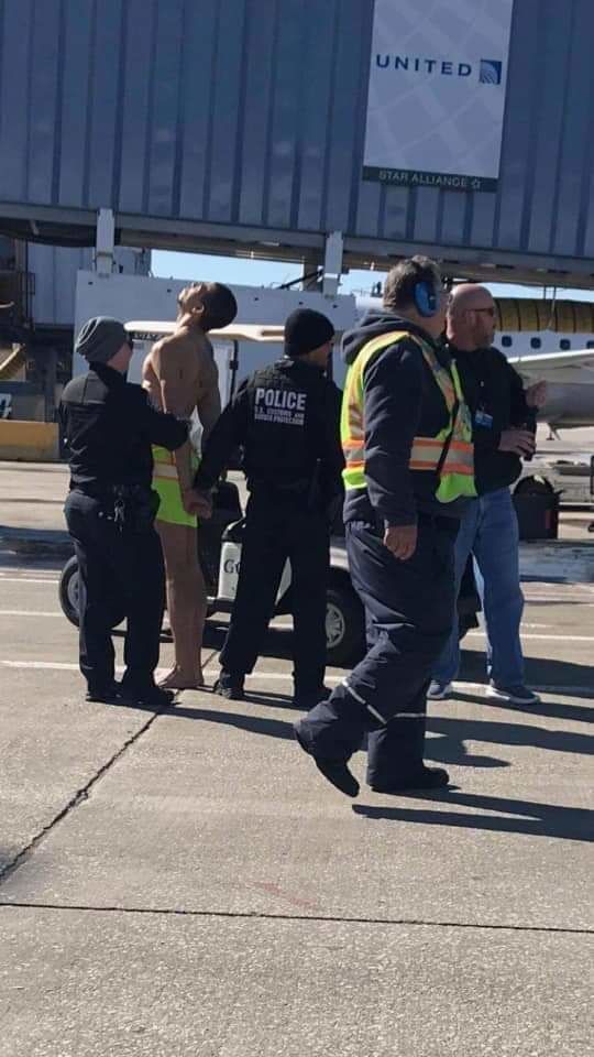 Полиция арестовала голого пассажира и прикрыла его жилетом.
