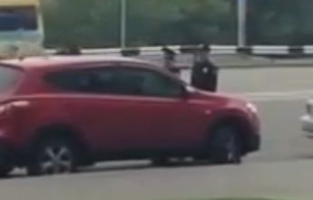 Женщина на красном джипе припарковала свой автомобиль на автобусной остановке.