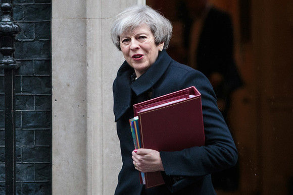 Theresa May este scoasă în grabă într-o curte interioară a palatului Westminster. 