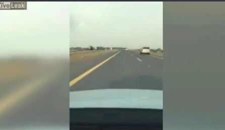 Водитель автомобиля несется по дороге в крайнем левом ряду, обгоняя другие машины.