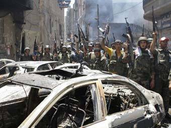 Сирийские солдаты празднуют победу над повстанцами в Дамаске. Фото: ©AFP