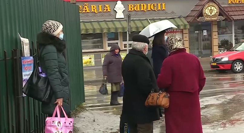 На Рышкановке люди ждут общественный транспорт на дороге.
