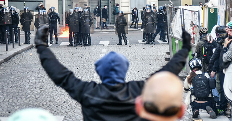 В Париже протестующие забросали полицейских бутылками и петардами.