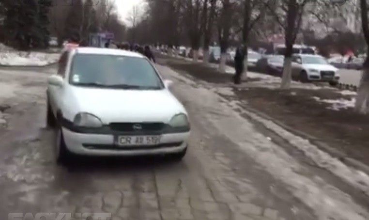 Автомобиль, едущий посреди тротуара, задевает пешехода. 