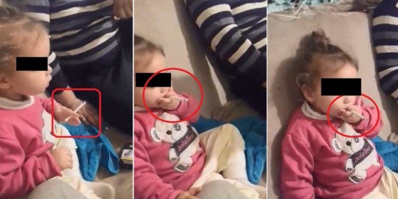 Revoltător: O fetiță de doi ani fumează, îndemnată de mama sa