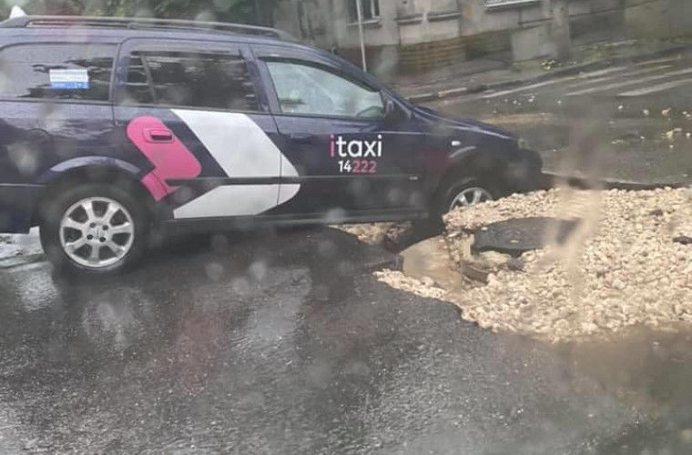 В столице машина службы такси попала в яму посреди дороги.
