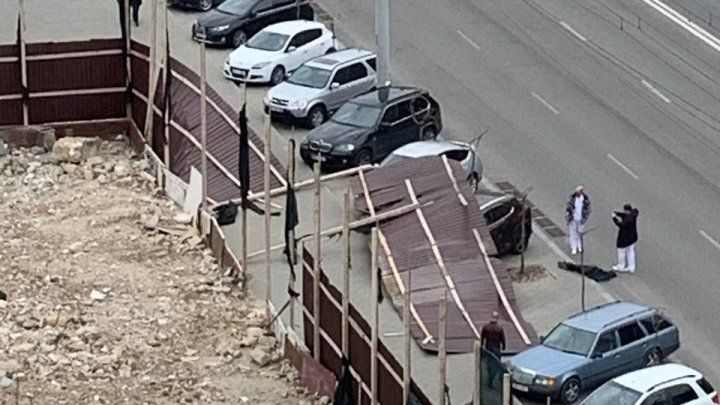 В Кишиневе часть забора снесло ветром на припаркованные машины.