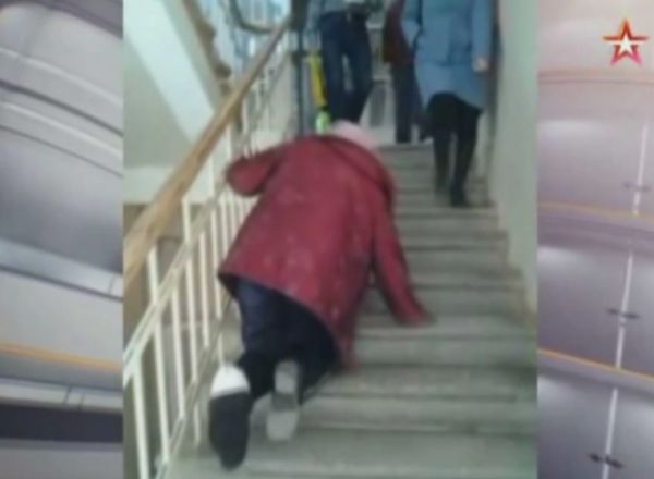 O femeie, in varsta de 69 de ani, a fost filmata cum urca pe scari la etajul 2 in genunchi, avand un picior fracturat. Foto: protv.md
