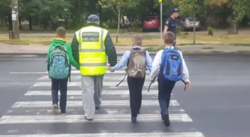 Полицейские и общественники помогают школьникам переходить с.