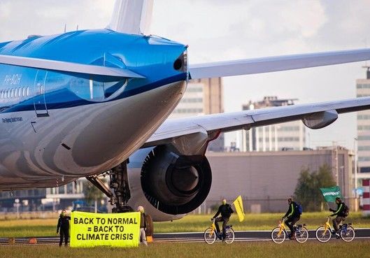 Члены Greenpeace протестуют против выплат авиакомпаниям.