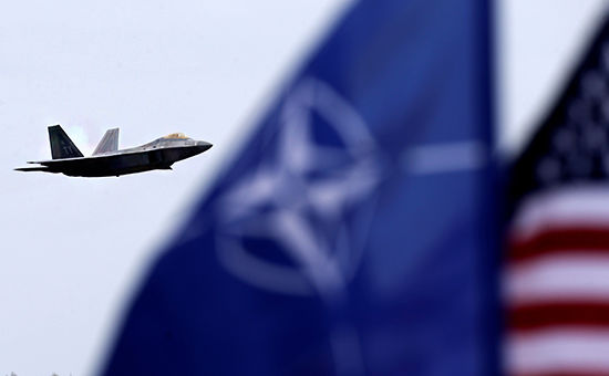 Истребитель ВВС США F-22 Raptor, флаги НАТО и США на авиабазе Шяуляй в Литве. Фото: reuters.com
