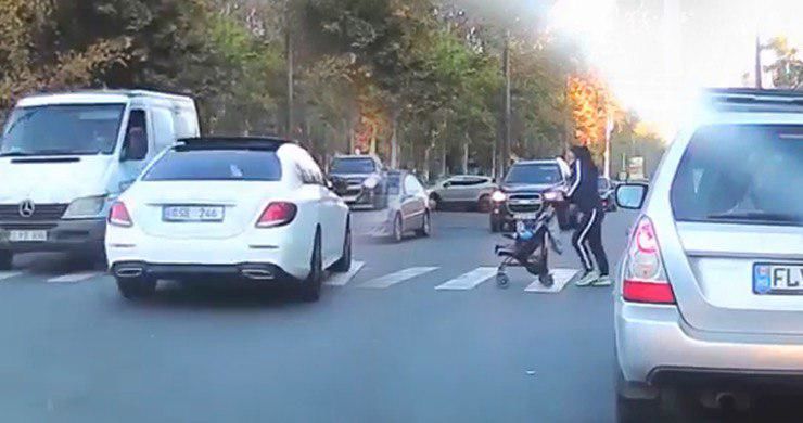 В столице автомобиль едва не сбил женщину с ребенком на переходе.