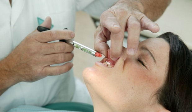 Dental Vibe se aplică la nivelul gingiilor în timpul injecţiilor anestezice cu novocaină