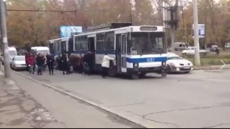 Zeci de oameni împing un troleibuz pe strada Alba Iulia. Foto: smotra.md