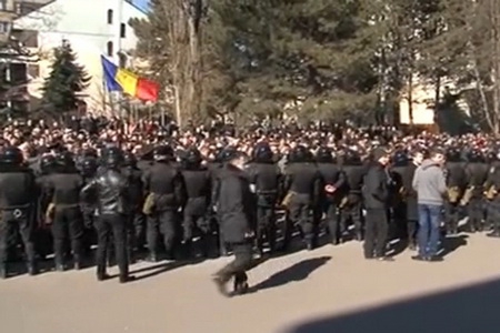 Экипированные полицейские оттесняют толпу, протестующую против отставки правительства, от парламента.