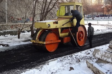 Коммунальщики укладывают асфальт.