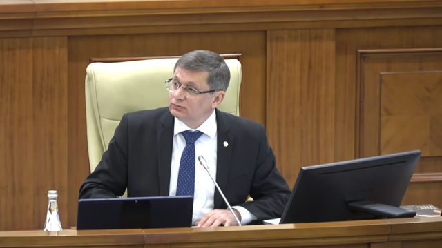 Grosu s-a adresat deputaților Parlamentului cu expresia „Dragi români”.