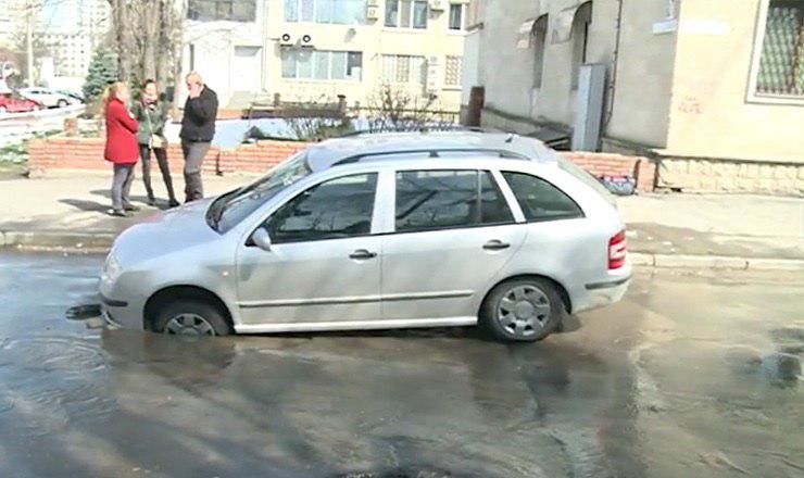 Maşină blocată într-o gaură formată în asfalt pe o stradă din Capitală. Foto: Captură video