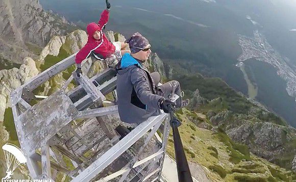 Doi tineri au făcut echilibristică în vârful crucii de pe Caraiman.