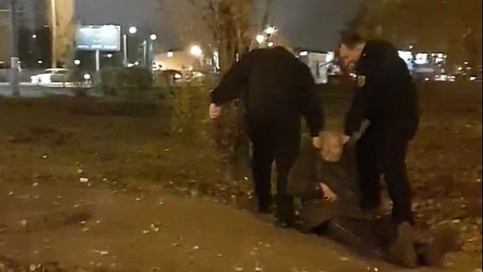 На кадрах видно, как двое мужчин в форме охранников волочат по асфальту мужчину. 