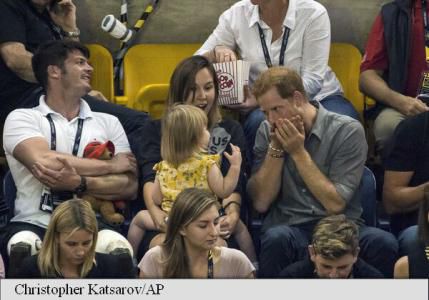 Scenă adorabilă la Jocurile Invictus: o fetiță fură popcorn din punga prințului Harry. Foto: AP Photo