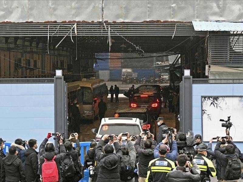 Эксперты ВОЗ прибыли на рынок под усиленной охраной сотрудников службы безопасности.