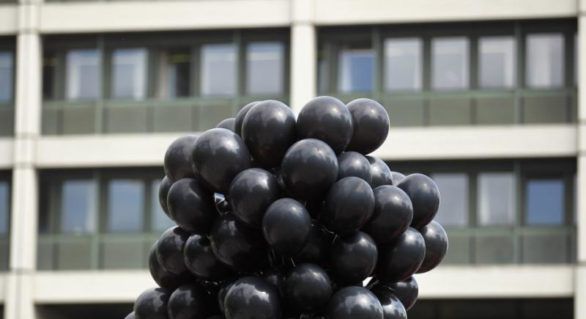 Sute de baloane negre pe cerul unei țări balcanice. 