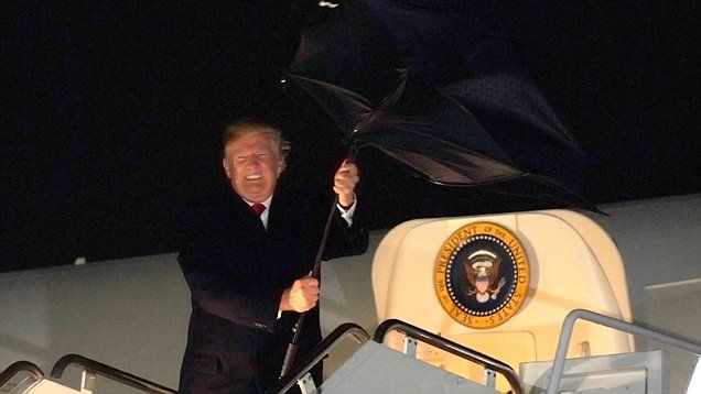 Дональд Трамп не смог справиться с зонтом, который вывернуло наизнанку из-за ветра. 