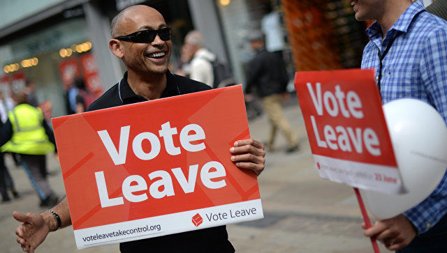 Собравшиеся держат в руках национальные флаги и скандируют "Brexit означает Brexit, выход, выход, выход!".
