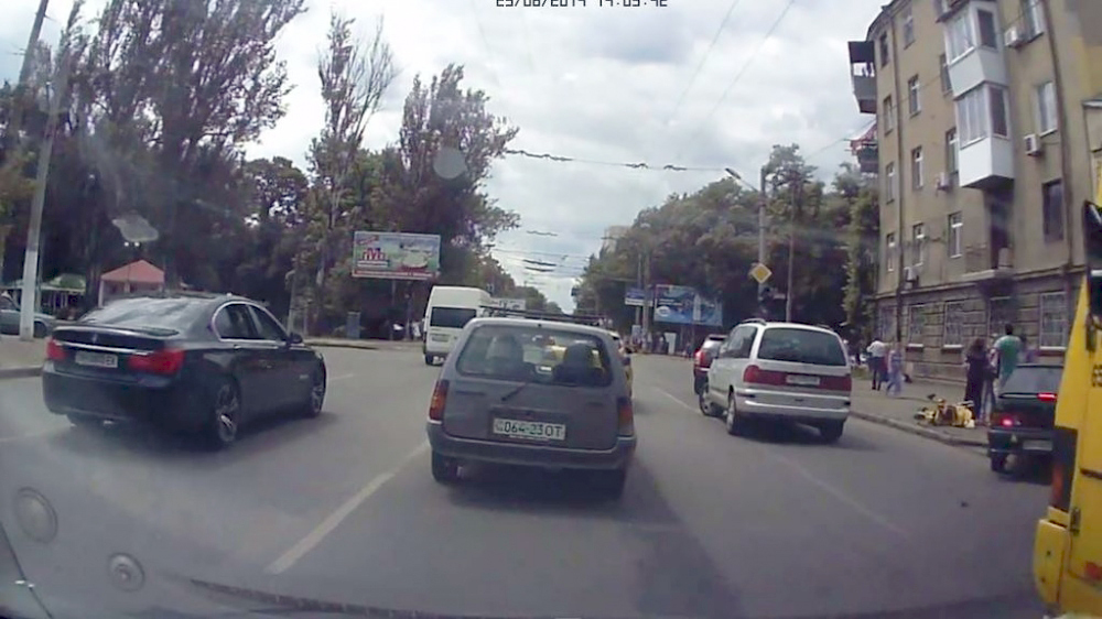Женщины с колясками вышли на проезжую часть перед пешеходным переходом на желтый сигнал светофора.
