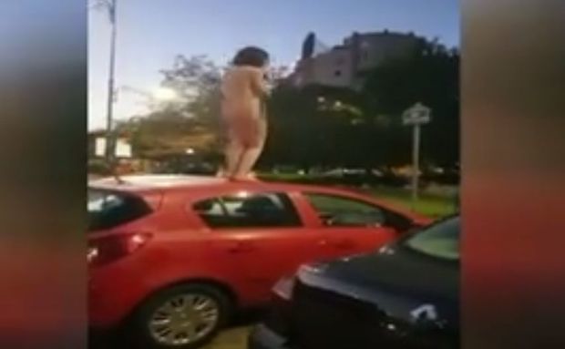 O femeie s-a dezbrăcat în pielea goală și s-a urcat pe o mașină. Foto: libertatea.ro