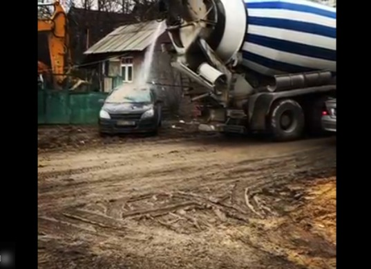 Maşină peste care a fost turnat beton, spălată direct în stradă