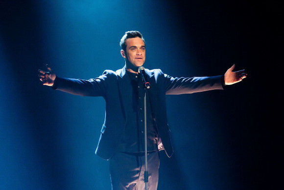 Robbie Williams a apărut nud, acoperit doar de propria carte. Foto: click.ro