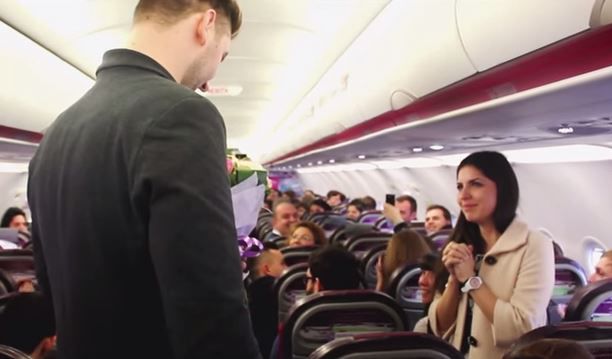 Он взял подготовленный заранее букет цветов, кольцо и попросил любимую выйти за него замуж на глазах у сотен пассажиров.