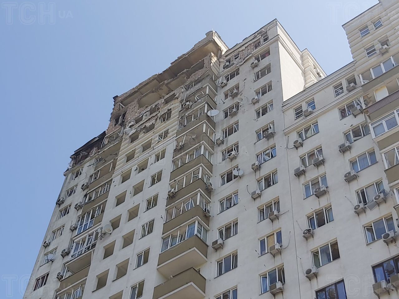 Вокруг многоэтажки все завалено битым кирпичом и кусками бетона. 