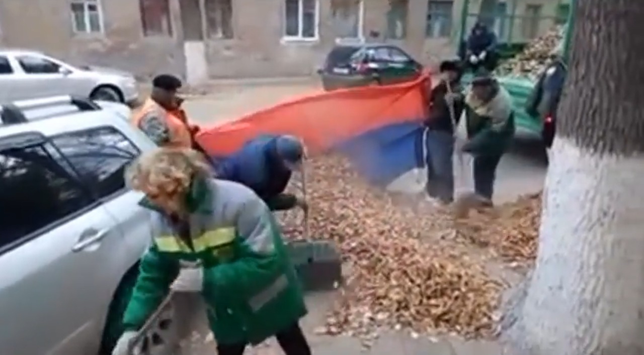 Măturătorii din oraşul Volgograd din Rusia folosesc drapelul naţional pe post de pungă pentru a strânge frunzele de pe stradă.