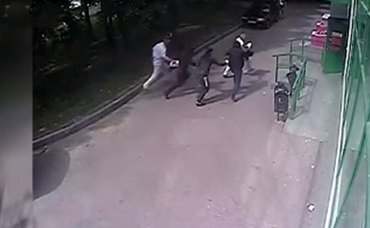 На кадрах видно, как двое мужчин стоят у отделения Сбербанка.