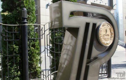 Графический символ сделан из стали, в него вставлена стилизованная бронзовая монета в 1 рубль.