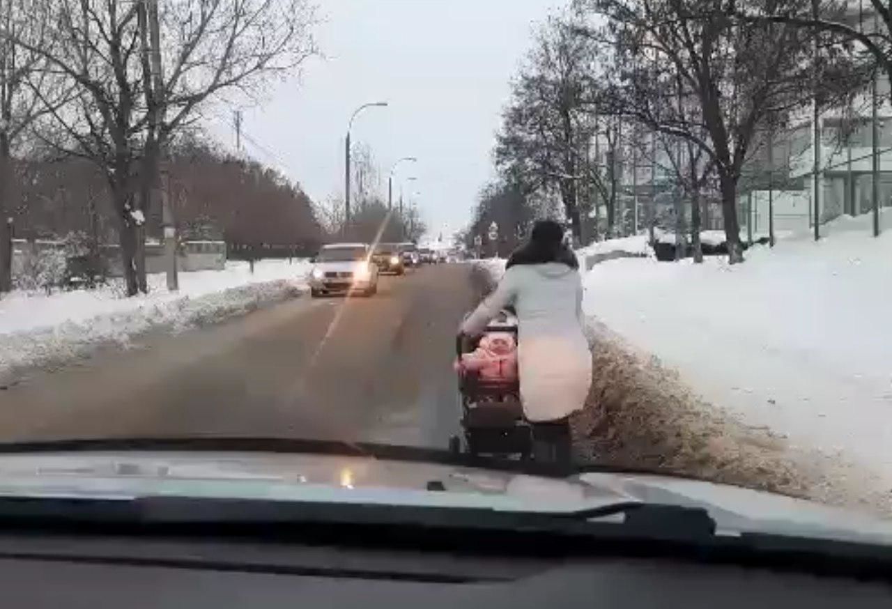 Пешеходы во избежание падений предпочитают двигаться по обочине дороги, а не по обледенелому тротуару.