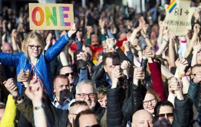 Демонстранты держатся за руки, протестуя против гомофобии.