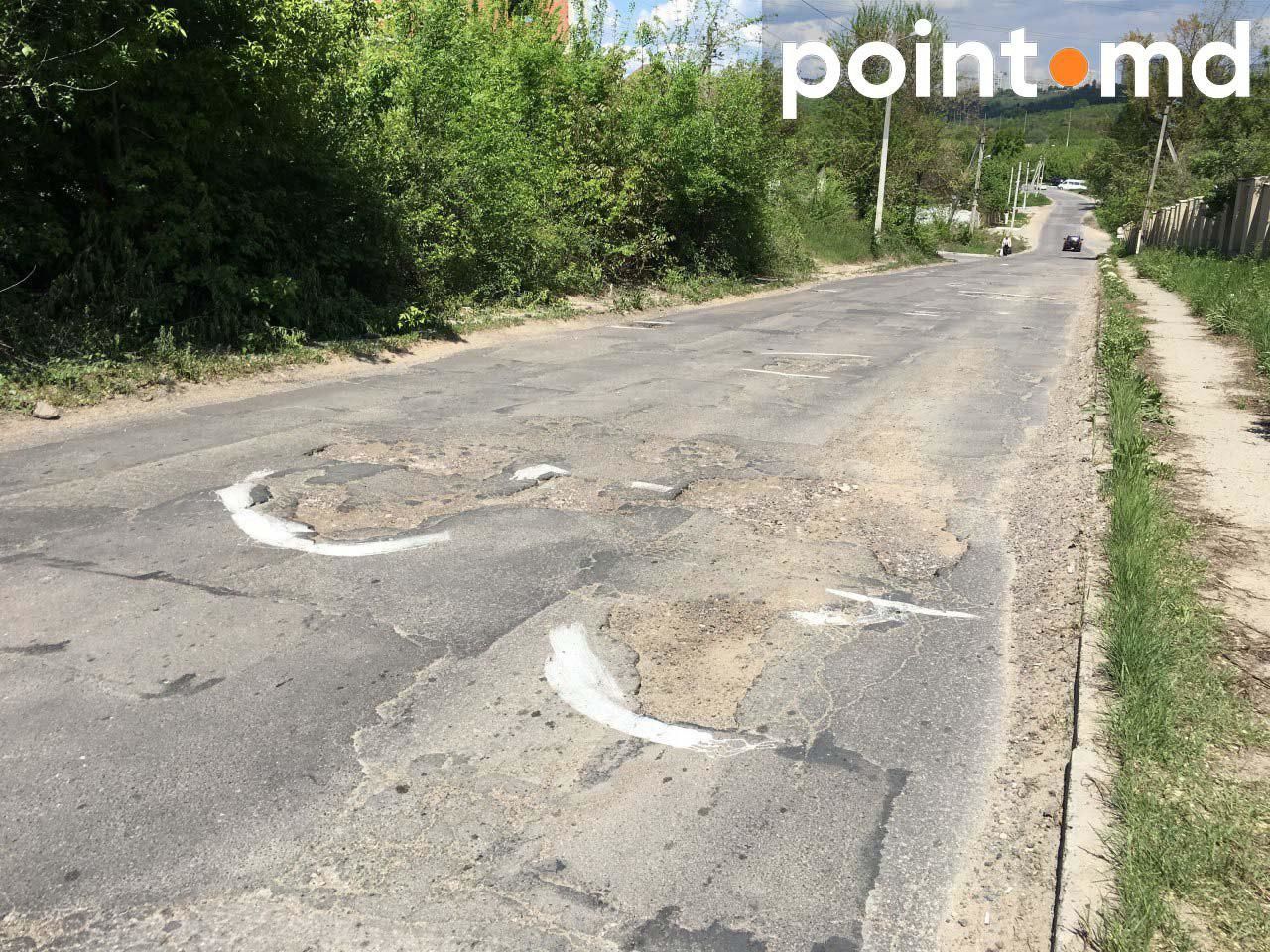 Жители столичной улицы краской обводят ямы на дороге