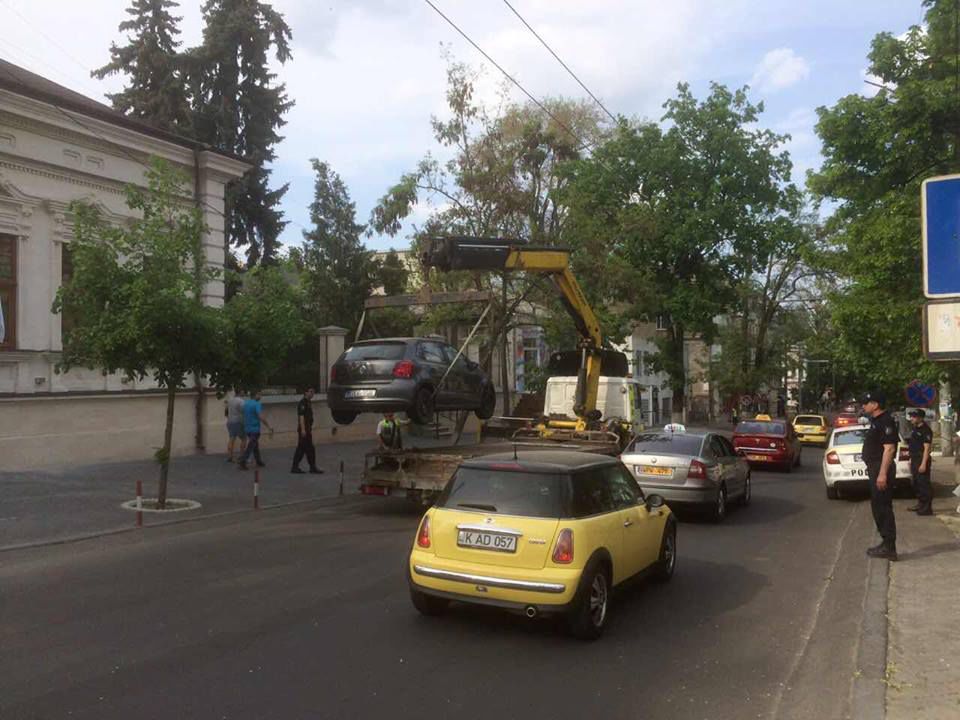 Ghinion pentru un șofer! Excavatorul i-a ridicat mașina parcată în centrul capitalei