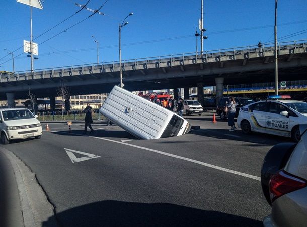 В Киеве микроавтобус "утонул" в яме посреди дороги