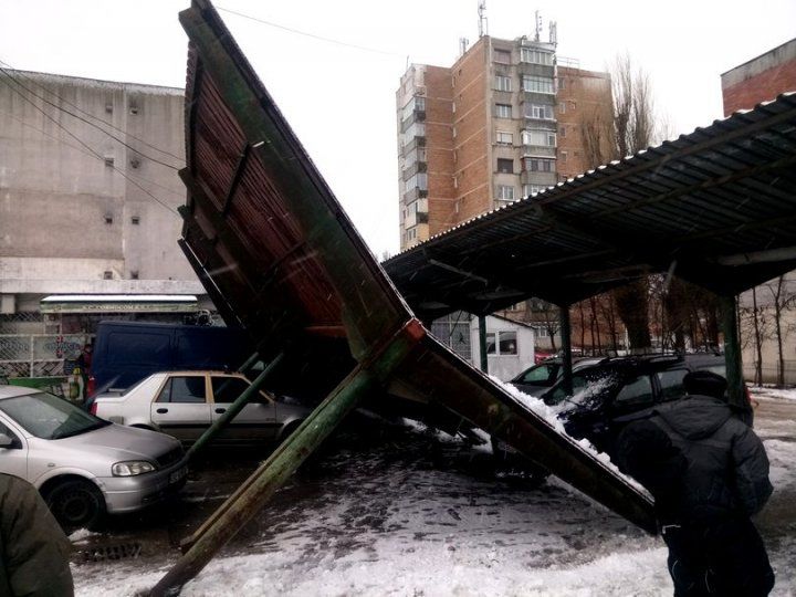 Două maşini, grav avariate, după ce un acoperiş metalic a căzut peste ele