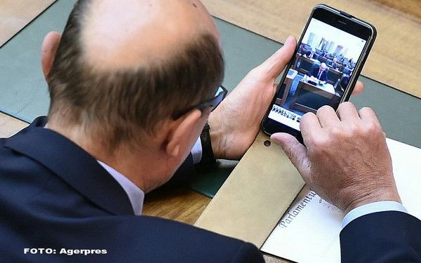 Traian Basescu, surprins de fotografi in timp ce-i trimite Elenei Udrea o poza