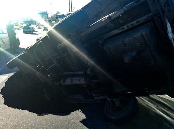 В Киеве микроавтобус "утонул" в яме посреди дороги