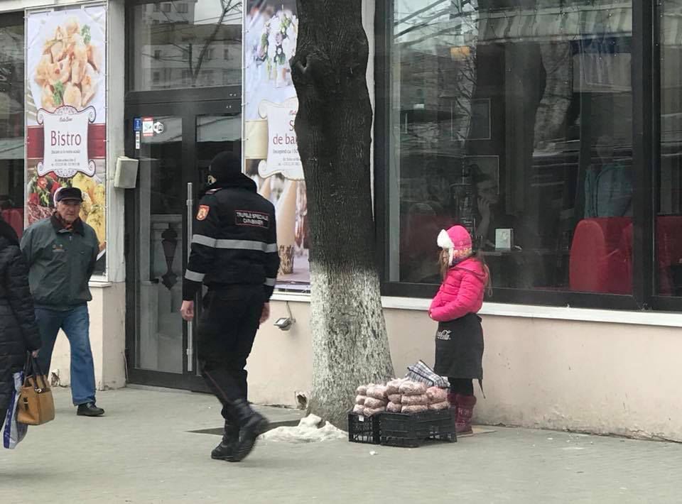 O fetiță vinde fasole în centrul Capitalei