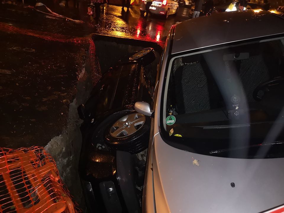 В Бухаресте авто полностью провалилось в огромную яму на дороге